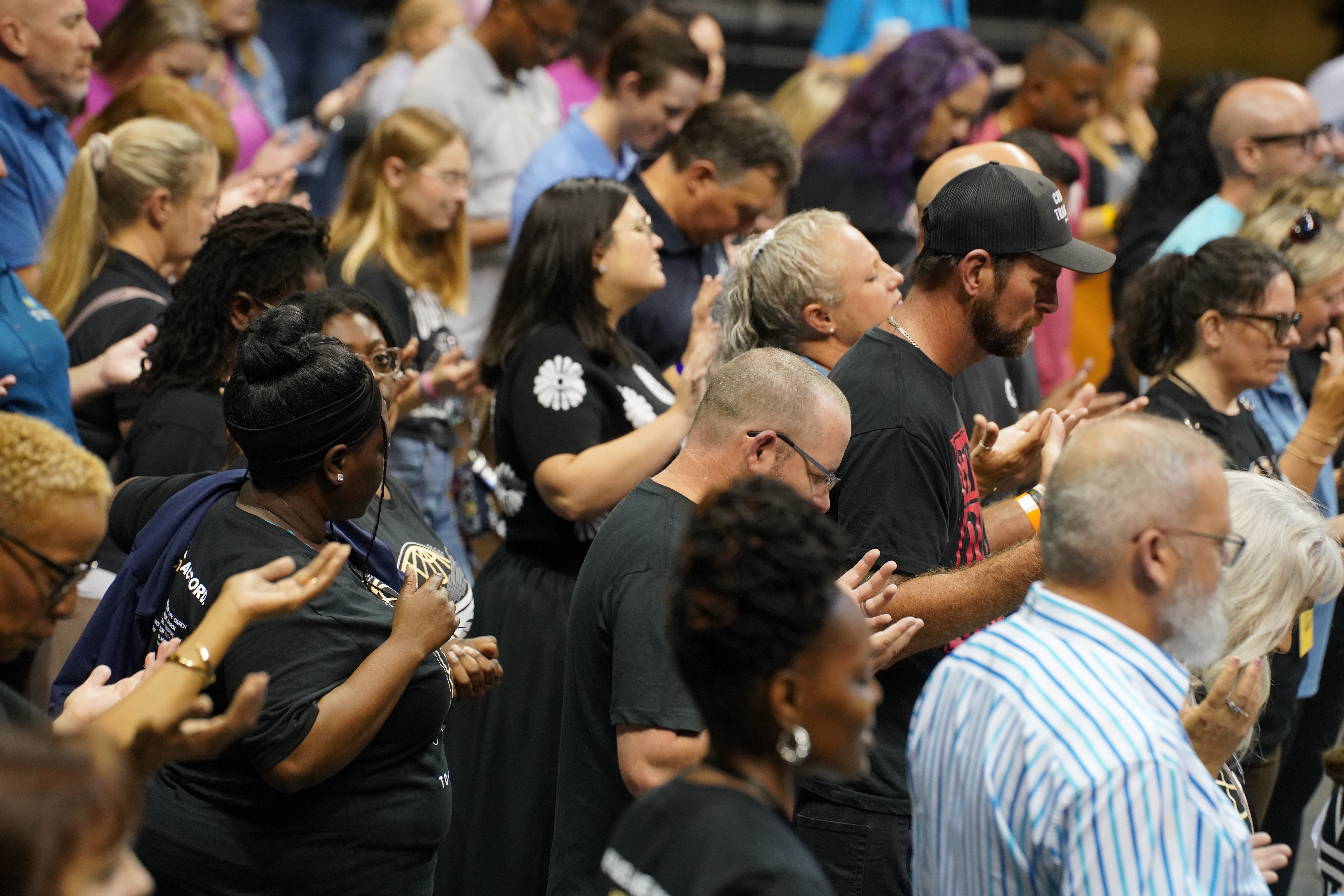 Crowd praying together at To·Gather